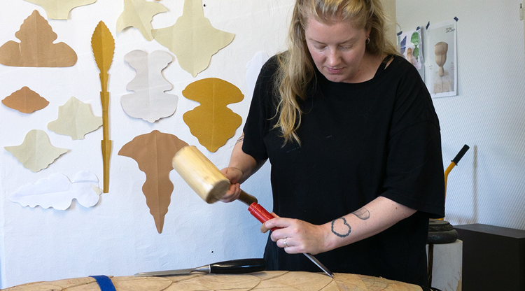 Konstnären Sanna Lindholm skulpterar i trä