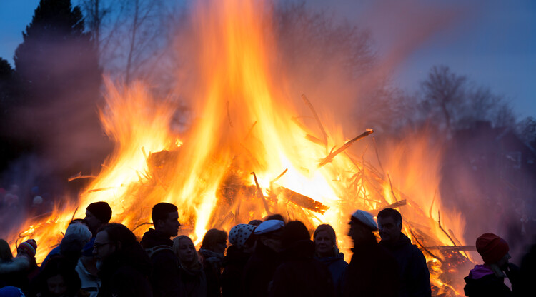 Människor vid brasa på valborg.