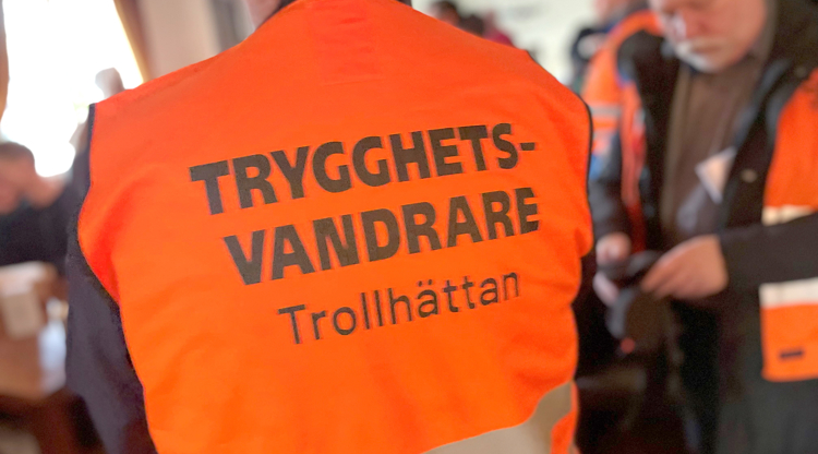 ryggtavla med orange väst med text "Trygghetsvandrare Trollhättan"