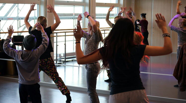 Personer dansar i en lokal.