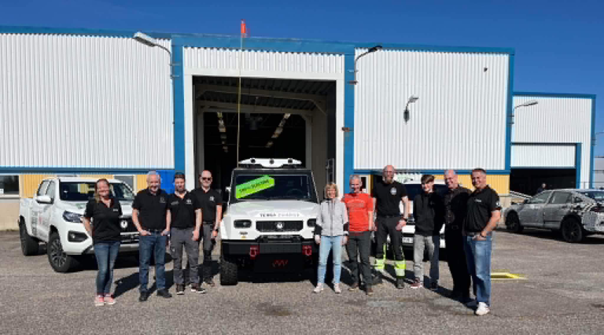 Bild på gruvbilen samt på representanter från de som byggt den från JMV och T-engineering