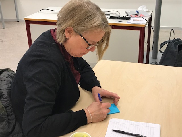 n kvinna som skriver på en post-it-lapp