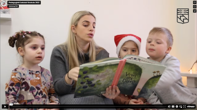Förskollärare läser bok för tre barn