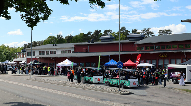 Stadståg och folksamling utanför byggnad under stadsfestival.