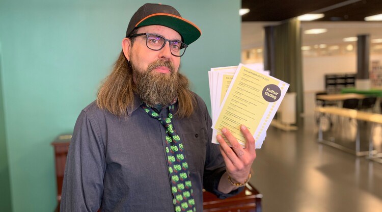 Person håller upp programblad.