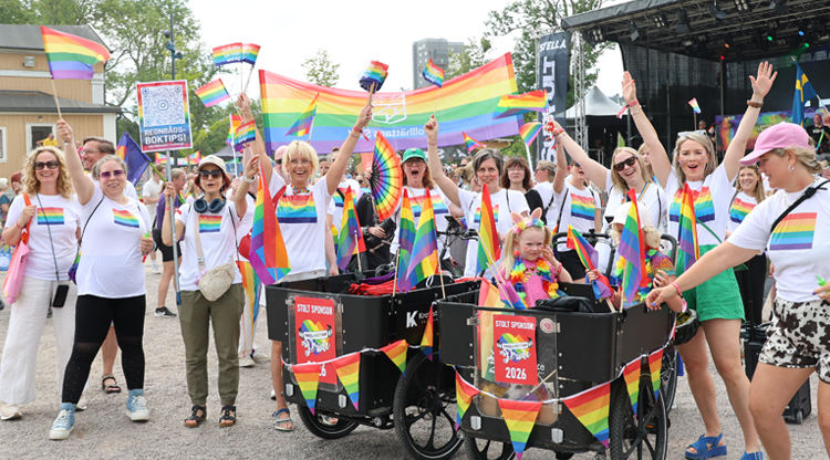 Flera människor i pridefärger framför scen i Stadsparken