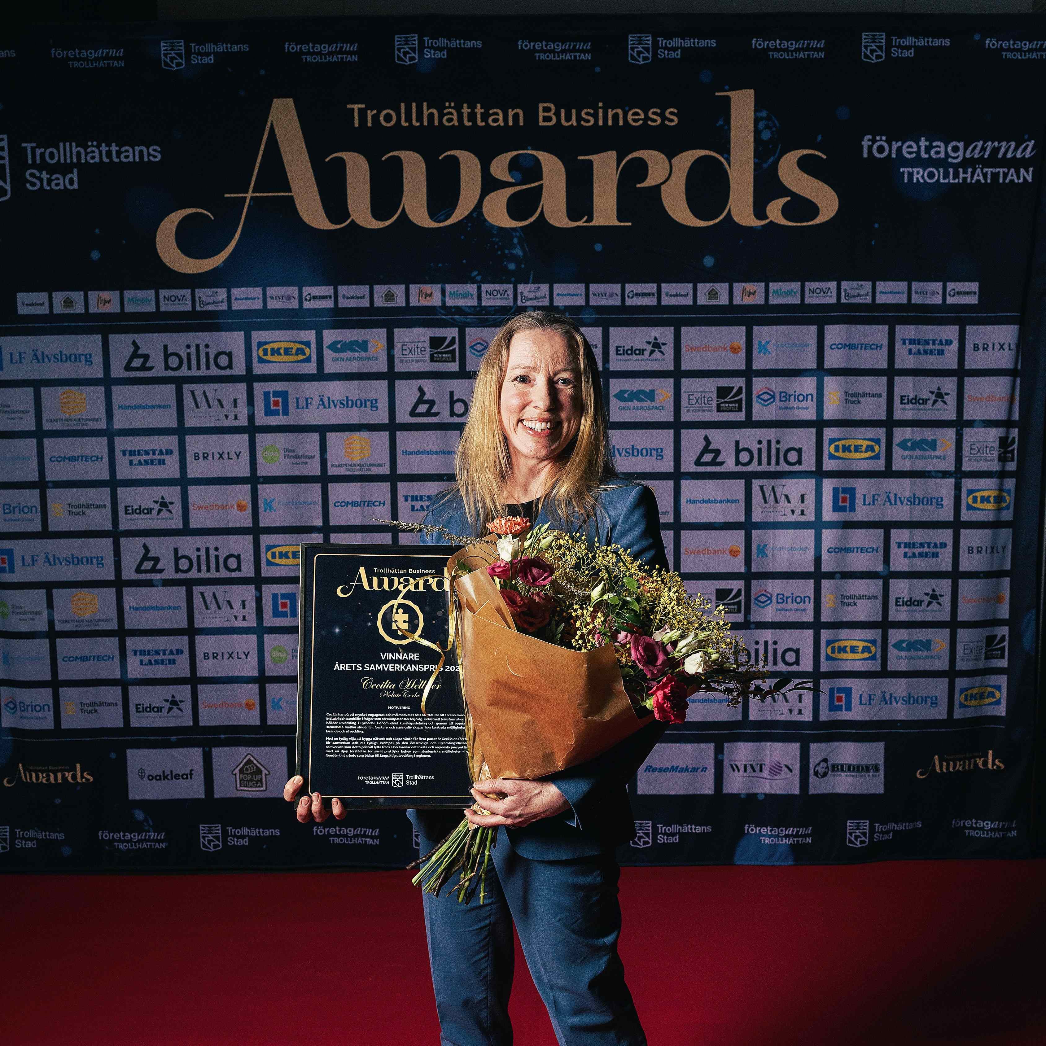 Bild p&aring; representant fr&aring;n f&ouml;retaget med blommor och diplom