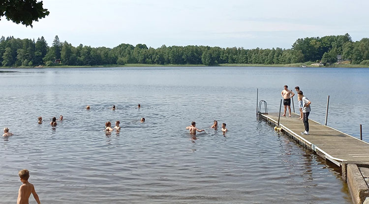 Ukrainska ungdomar badar i Öresjö på sommarkollot 2025.
