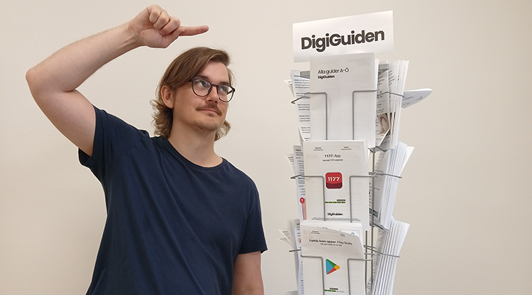 Man pekar på ett ställ med pappersguider