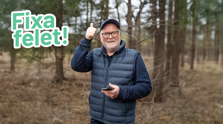En leende man håller en mobiltelefon i ena handen och gör tummen upp med den andra handen. På bilden står texten "Fixa felet!". Foto.