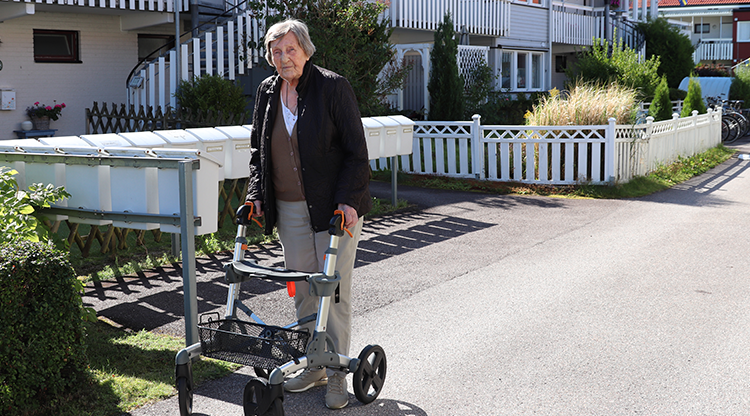 Äldre kvinna på promenad med sin rollator