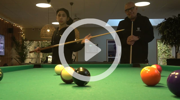 En ungdom och en vuxen spelar biljard, ovanp&aring; bilden ligger en playsymbol f&ouml;r att illustrera att man l&auml;nkas till en film om man klickar p&aring; bilden.