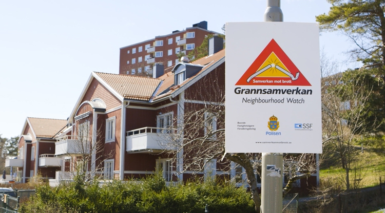bostadsområde med skylt: grannsamverkan mot brott