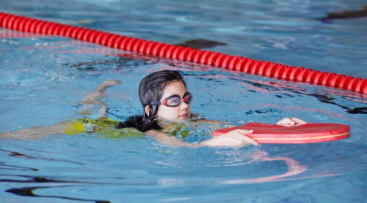 Barn som simmar i pool