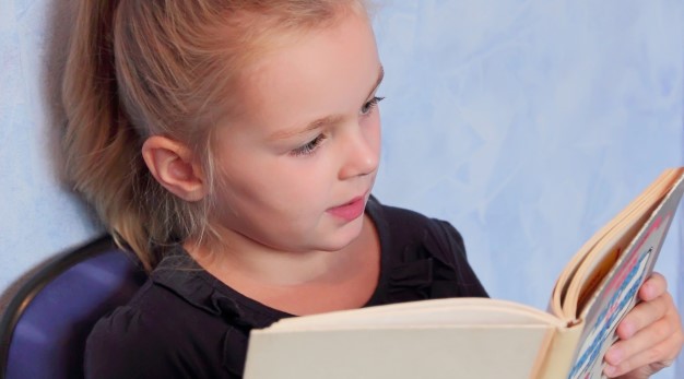 skolflicka läser i en bok