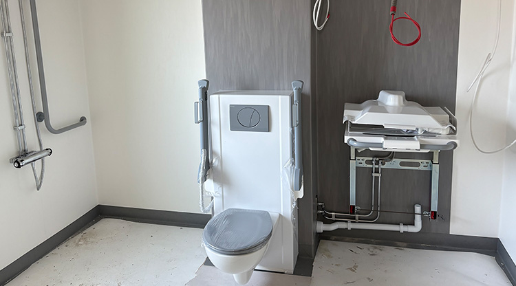 Höj- och sänkbar toalettstol i en pågående renovering av ett badrum