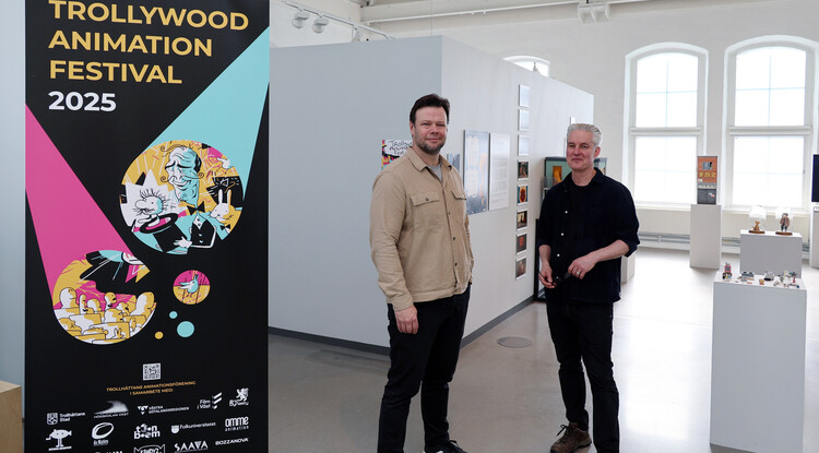 Två personer står vid en utställning i en konsthall.