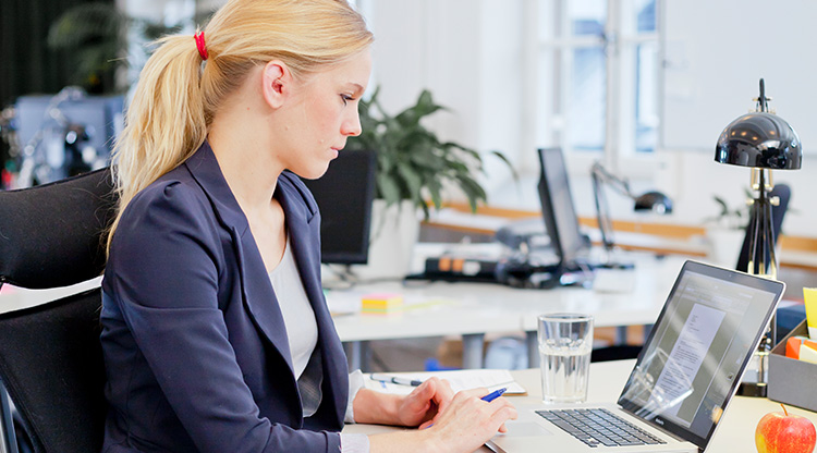 En kvinna sitter vid datorn