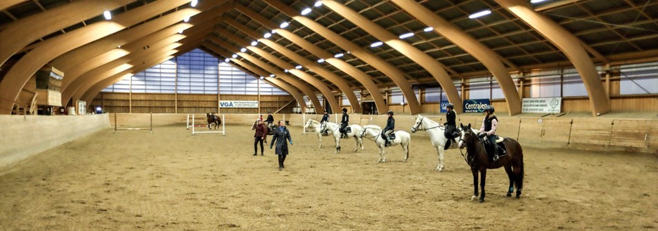 Barn sitter på hästar på en ridanläggning.