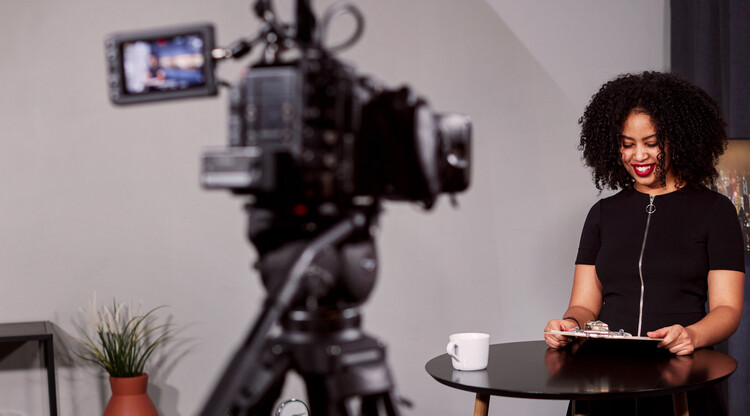 Kvinna står framför kamera.