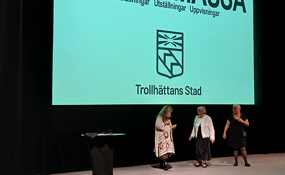 Tre kvinnor på en stor scen.
