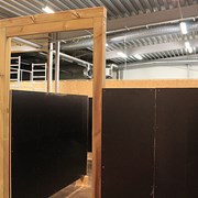 Bilden är ett foto på en labyrint som ska byggs till lekplatsen. I bild syns labyrintens ingång och än så länge är väggarna svarta i väntan på de bilder som ska pryda labyrinten. 
