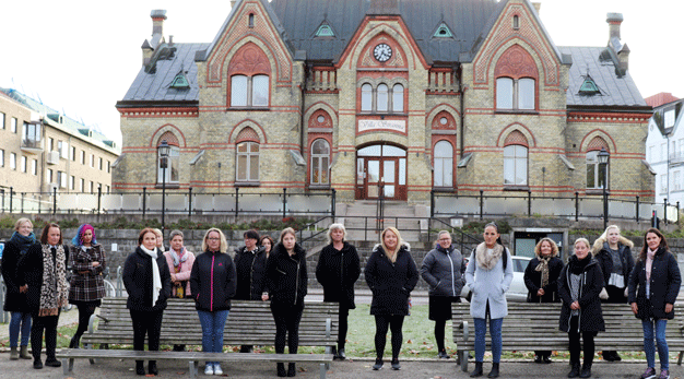 Flera personer står utomhus med jackor på sig framför Villa Stranna, en gammal byggnad i Trollhättan.