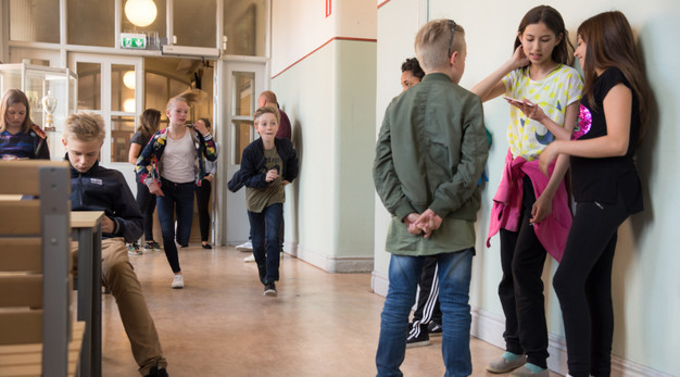 Bilden föreställer barn i en skolkorridor. 