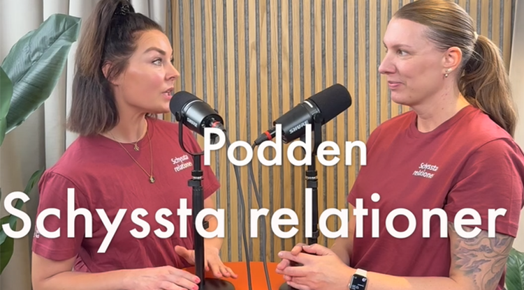 två kvinnor står vid bord med mikrofoner och gör en poddinspelning