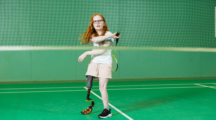 Flicka spelar badminton.