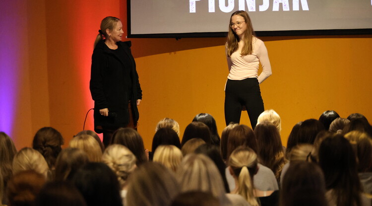 Två personer på scen inför publik.