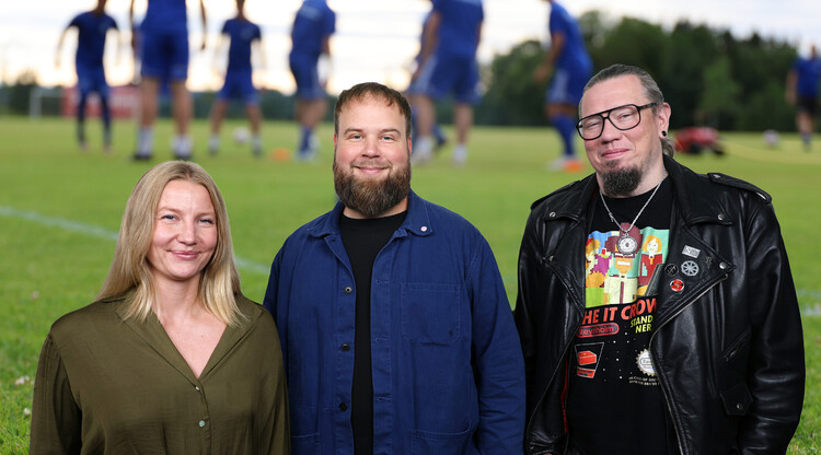 Tre personer. I bakgrunden syns en fotbollstr&auml;ning.