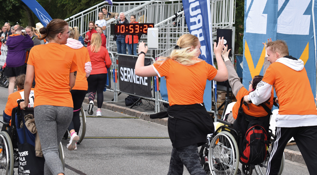 Glada deltagare från Ocab-loppet passerar mållinjen.