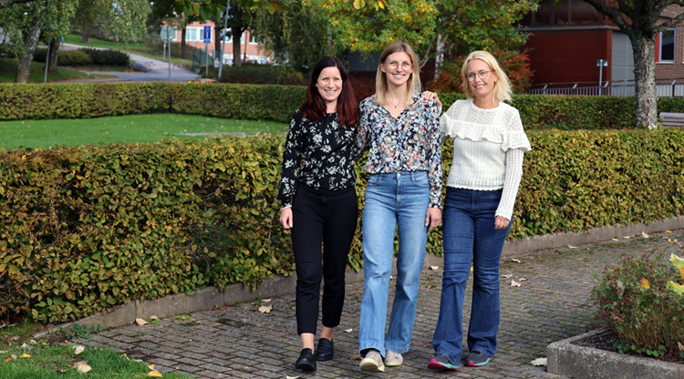 Tre personer som går tillsammans utomhus