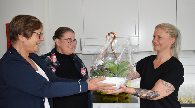 Förvaltningschef Lena Johansson räcker över blomma till Gabbie Bergman på den dagliga verksamheten VIGGEN