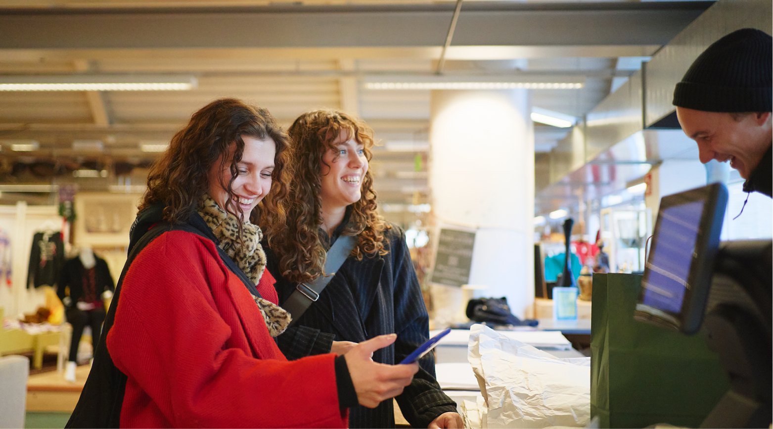 Två kvinnor betalar i butik