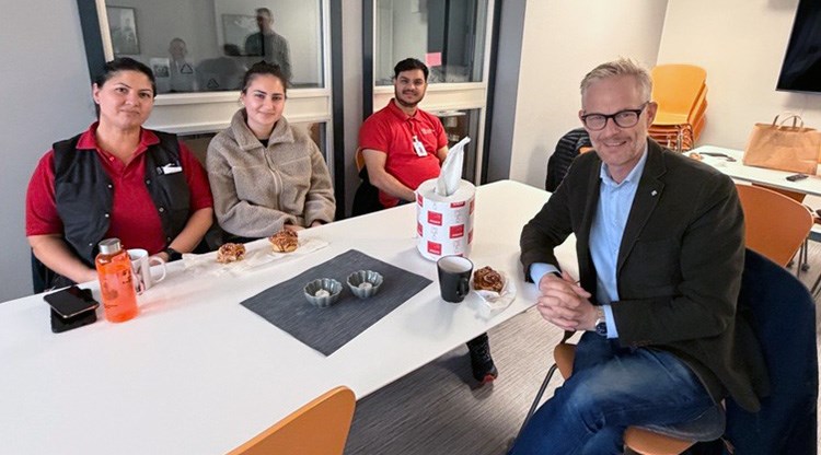 Fyra personer sitter runt ett bord. 