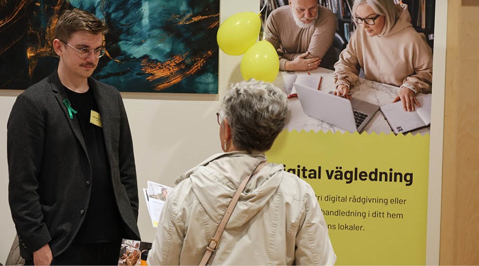 Dam pratar med man på en mässa