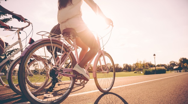 Cyklister som cyklar mot solen på en landsväg