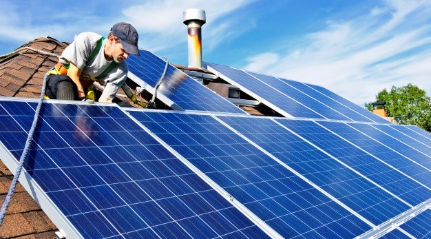 Ett tak där en man installerar solceller