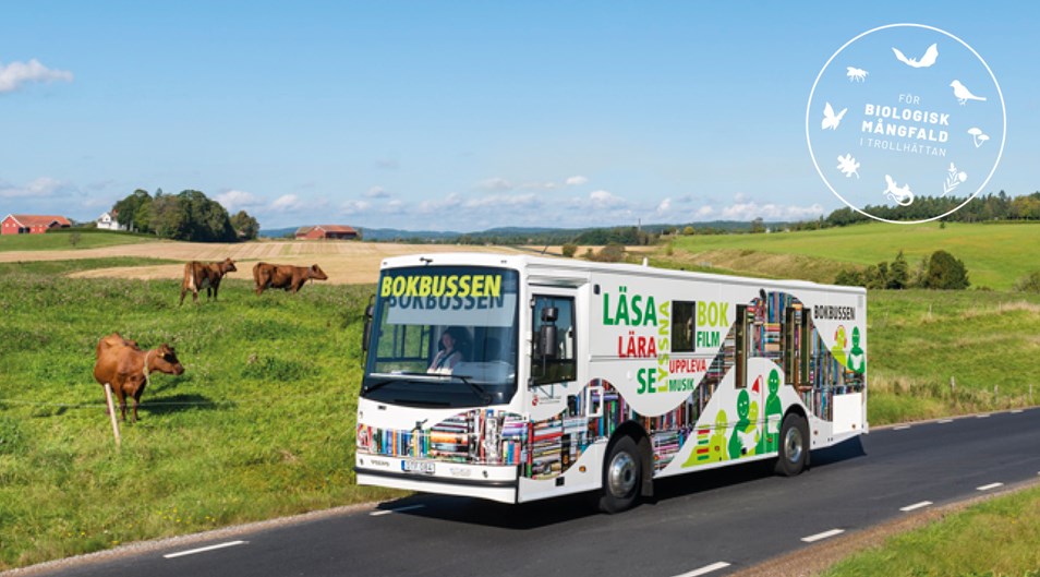Bokbussen åker på landsväg. Symbol med texten "Biologisk mångfald i Trollhättan". 