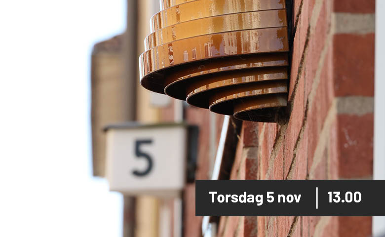 Bild på husfasad med tegel och en lamparmatur samt siffran 5. 
