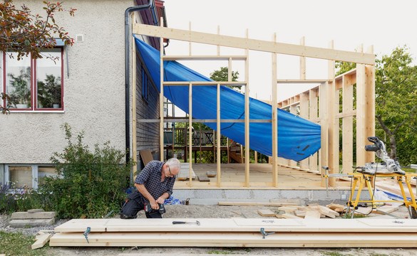 En man som bygger till på sitt hus. 