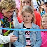 Bilden föreställer Monica Hansson tillsammans med Julia år år. Det är Julia som kom med idén till lekplatsen. Bilden är tagen precis innan de tillsammans ska klippa bandet och officiellt inviga lekplatsen. På bilden syns, förutom Monica och Julia, flera barn som väntar spänd på att få prova den nya lekplatsen. 
