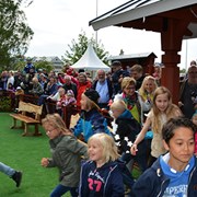 Glada barn som springer mot den nya lekplatsen