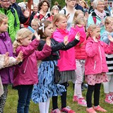Bilden föreställer vuxna och barn som sjunger och gestikulerar 