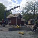 Skrotnisses stuga lyfts ned till lekplatsen. 