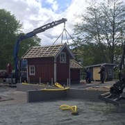 Skrotnisses stuga lyfts ned till lekplatsen. 