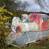 Ett tåg som skall finnas i lekplatsen står inplastat utanför och väntar på att få sin plats. 