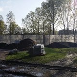 Högar med grus och jord ligger utanför byggarbetsplatsen.  